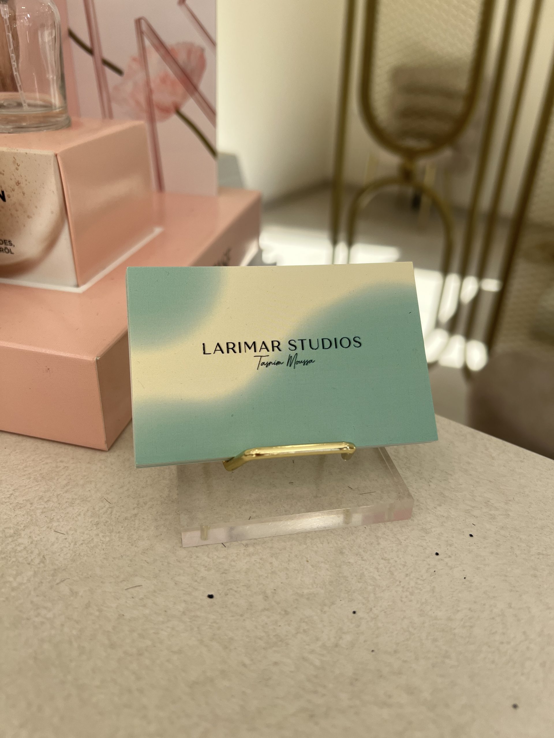 Visitenkarte von Larimar Studios im Kartenhalter auf der Salon-Theke